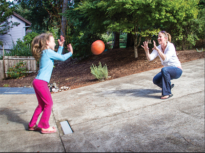 mom throws ball with her child, for article on autism and motor skills