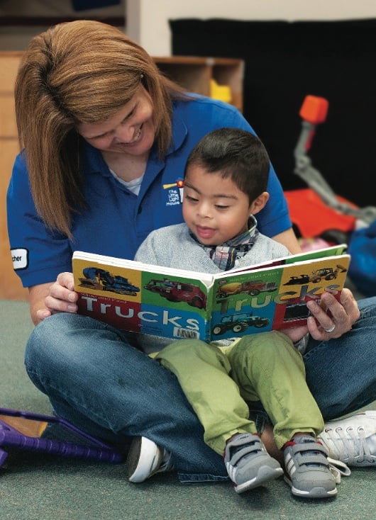 an adult reads to a child at little light house in tulsa