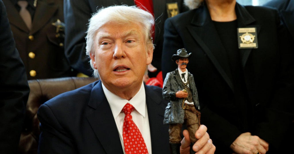 U.S. President Donald Trump receives a figurine of a sheriff during a meeting with county sheriffs at the White House in Washington