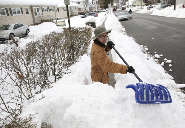 Zachary Durren shovels the sidewalk in front of the an apartment complex where he works as the super in Butler