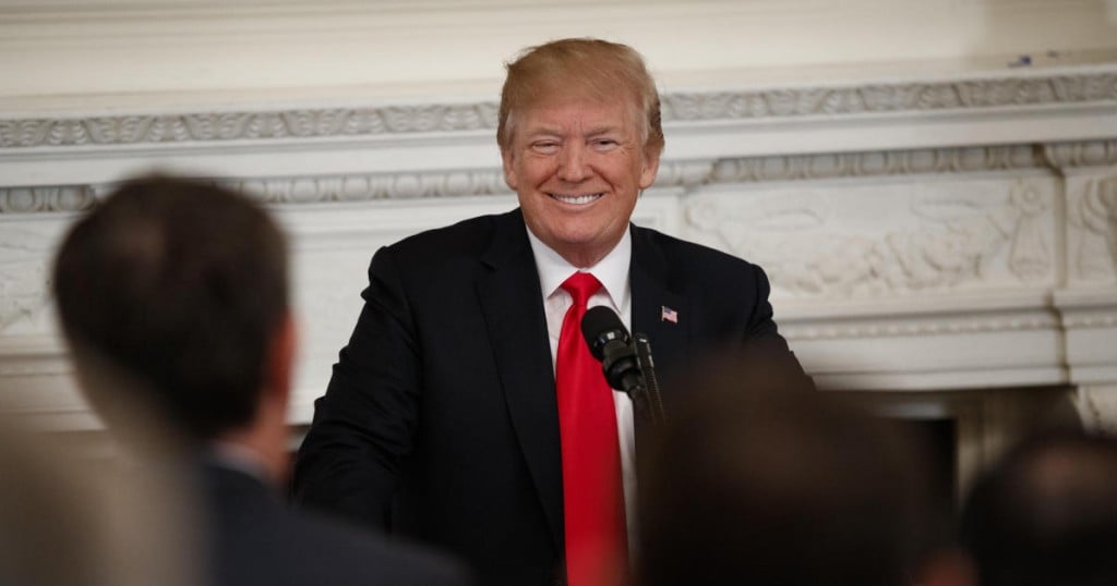 President Donald Trump smiles as he arrives to speak to members of the National Governors Association in the State Dining Room of the White House