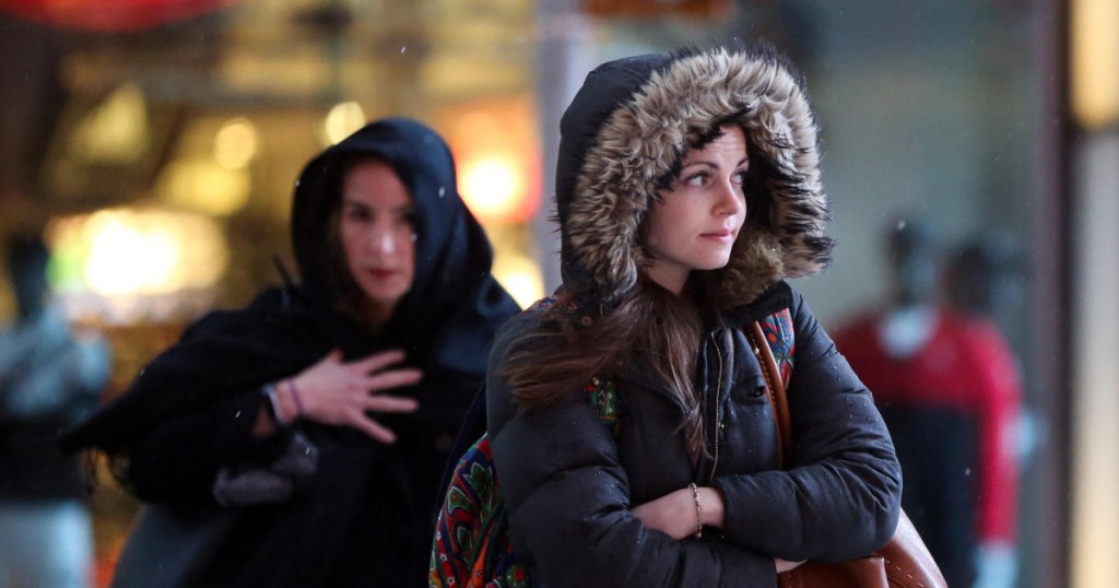 Women walk through the rain in Times Square in Manhattan in New York