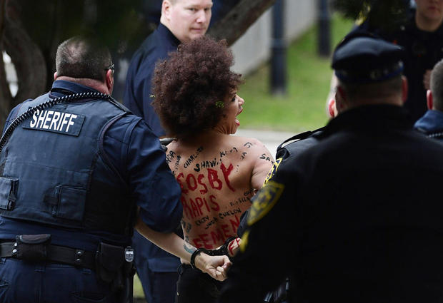 A protester is detained after Bill Cosby arrives for his sexual assault trial at the Montgomery County Courthouse