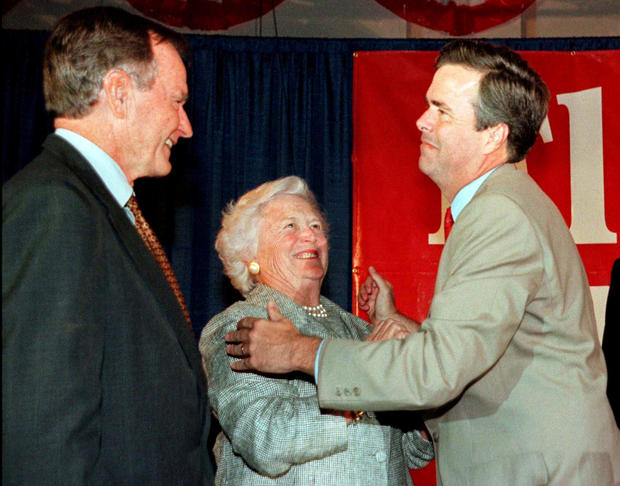 FILE PHOTO: Former President George Bush (L) and wife Barbara congratulate their youngest son Jeb Bush at the Republican gubernatorial candidate's victory party in Miami November 3. REUTERS/Colin Braley/File Photo