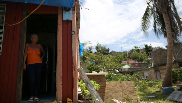 Bexaida Torres stands in the door of what is left of her home after Hurricane Maria hit the island in September
