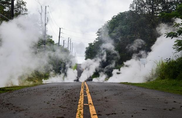 TOPSHOT - Steam rises from a fissure on a road in Leilani Estates subdivision on Hawaii's Big Island on May 4