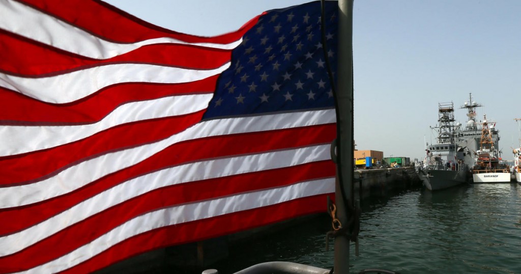 An American flag flies near US Navy boats docked at Bahrain's Salman port in the capital Manama