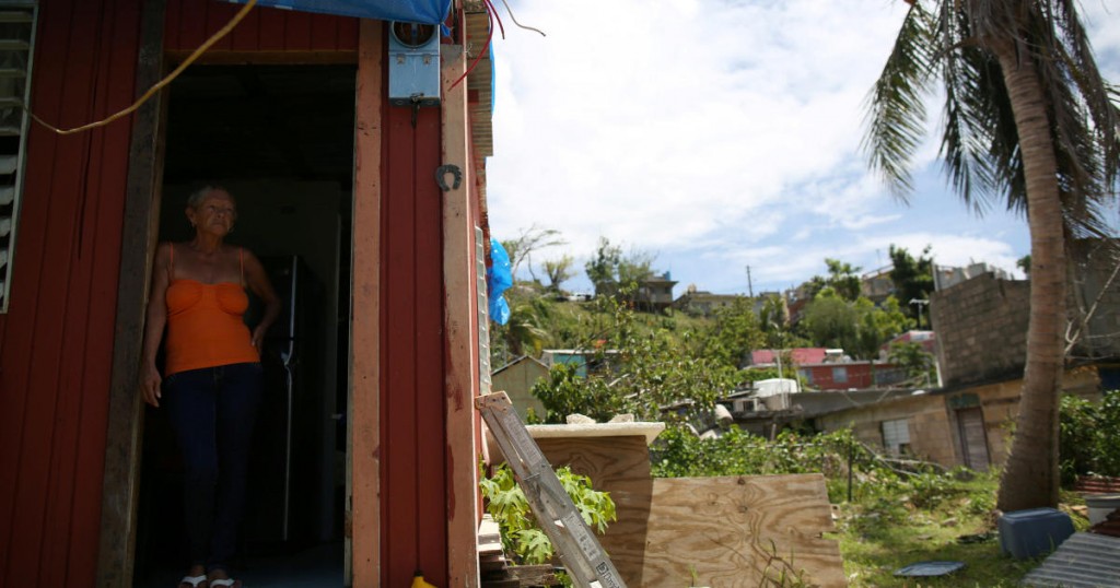 Bexaida Torres stands in the door of what is left of her home after Hurricane Maria hit the island in September