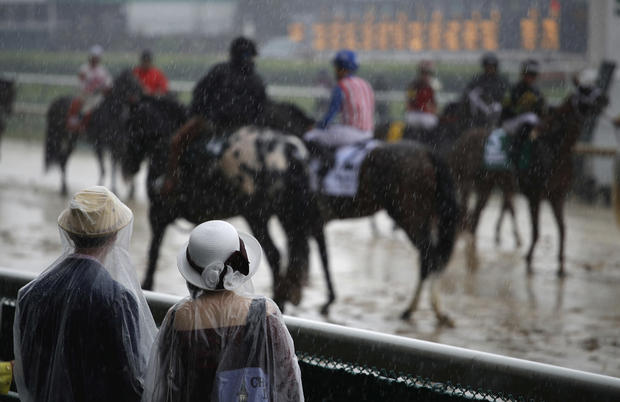 Fans watch race horses as they walk on the track before the 144th running of the Kentucky Derby horse race at Churchill Downs Saturday