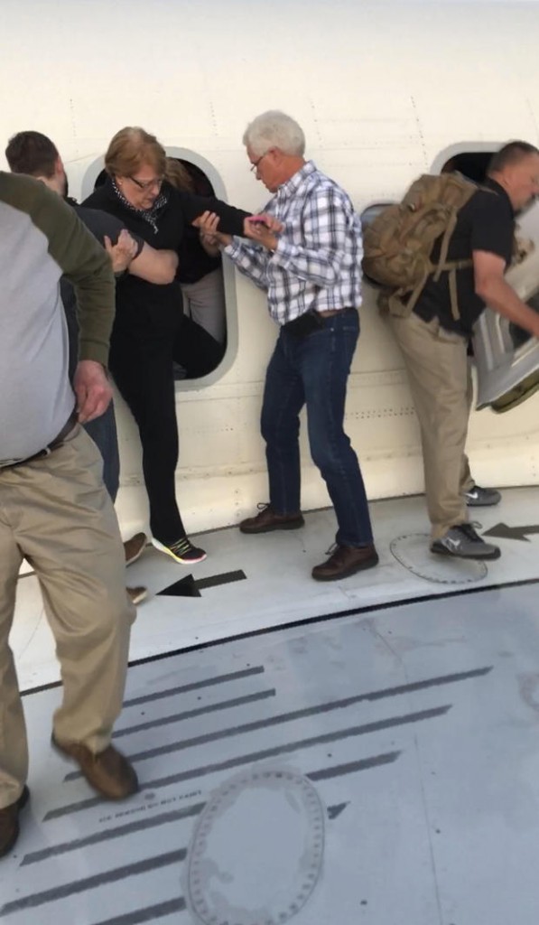 Passengers stand on the tarmac of Denver International Airport after being evacuated from a Delta flight from Detroit on Tuesday May 8