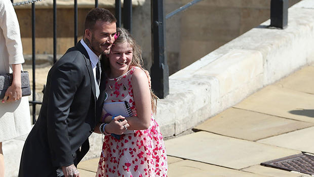 Former England footballer David Beckham (L) poses for a photograph with a young guest as he arrives for the wedding ceremony of Britain's Prince Harry