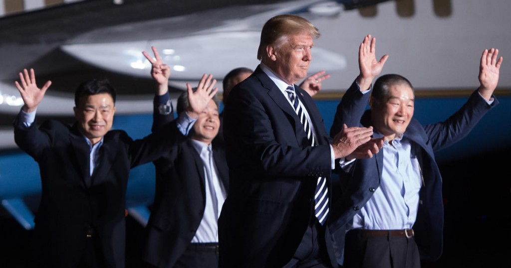 US President Donald Trump (2nd R) walks with US detainees Tony Kim (L)