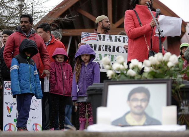 People gather near a photograph of Srinivas Kuchibhotla