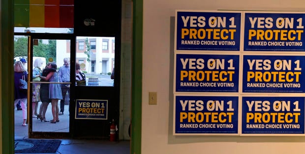 Supporters of the ranked-choice voting system embrace outside their primary night rally shortly after polls closed in Portland