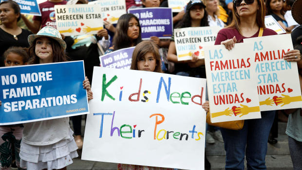 People hold signs to protest against U.S. President Donald Trump's executive order to detain children crossing the southern U.S. border and separating families outside of City Hall in Los Angeles
