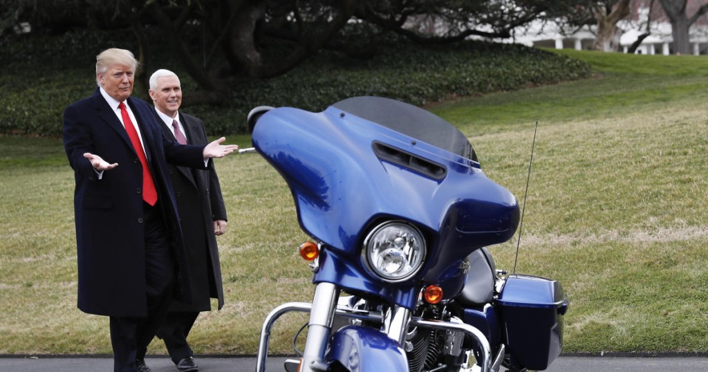 President Donald Trump and Vice President Mike Pence stop to admire a Harley Davidson motorcycle parked on the South Lawn of the White House in Washington
