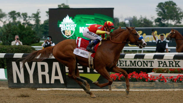 crosses the finish line to win the 150th running of the Belmont Stakes at Belmont Park on June 9