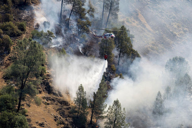 Crews battle the Ferguson Fire along steep terrain behind the Redbud Lodge along Highway 140 near El Portal in Mariposa County