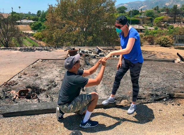 In this photo provided by the Santa Barbara County Fire Department resident Ishu Rao on one knee