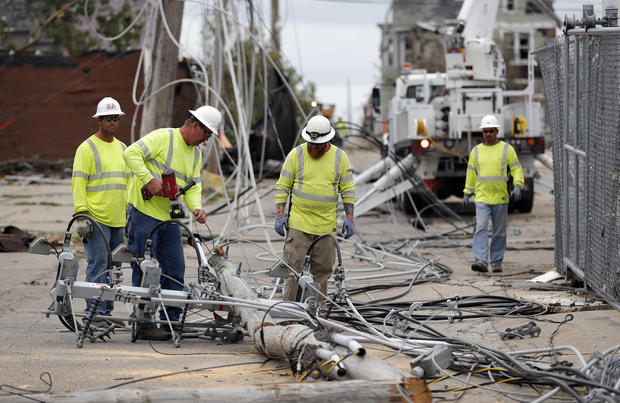 Utility workers repair downed power lines
