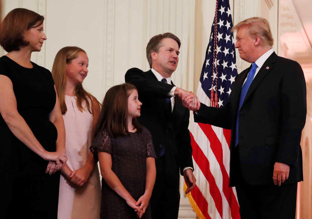 U.S. President Donald Trump shakes hands with Supreme Court nominee judge Brett Kavanaugh as wife Ashley Estes Kavanaugh and children look on in the East Room of the White House in Washington