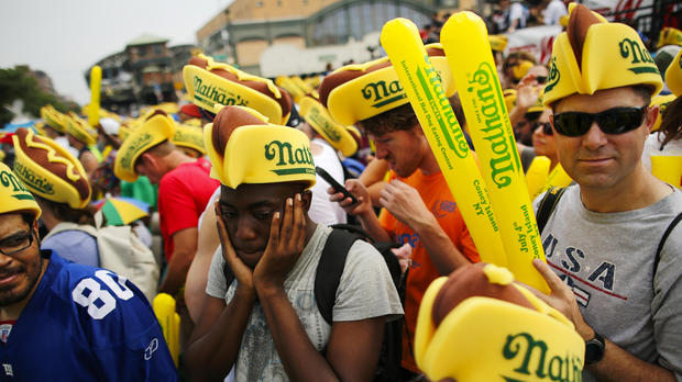 A man covers his ears from noise as people attend the annual Nathan's Famous hot dog eating contest on July 4, 2018, in the Coney Island neighborhood of the Brooklyn borough of New York City. 