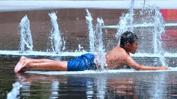 A boys cools off in the water play area at Grand Park in Los Angeles
