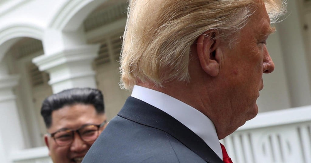 U.S. President Donald Trump and North Korea's leader Kim Jong Un walk together before their working lunch during their summit at the Capella Hotel on the resort island of Sentosa