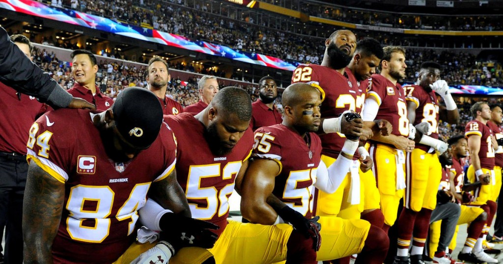 FILE PHOTO: Washington Redskins tight end Niles Paul (84) and linebacker Ryan Anderson (52) and Washington Redskins linebacker Chris Carter (55) kneel with teammates during the playing of the national anthem before the game between the Washington Redskins and the Oakland Raiders at FedEx Field in Landover