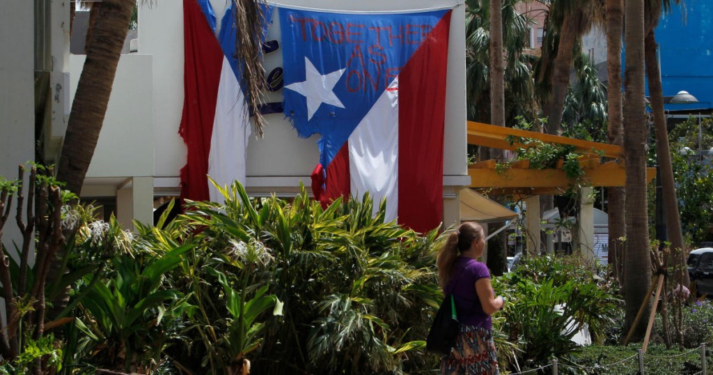 "Together as One" reads on a torn Puerto Rican Flag hanging from a hotel in the tourist zone of el Condado in San Juan