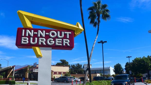 A driver pulls into the drive-thru lane at an In-N-Out Burger restaurant in Alhambra