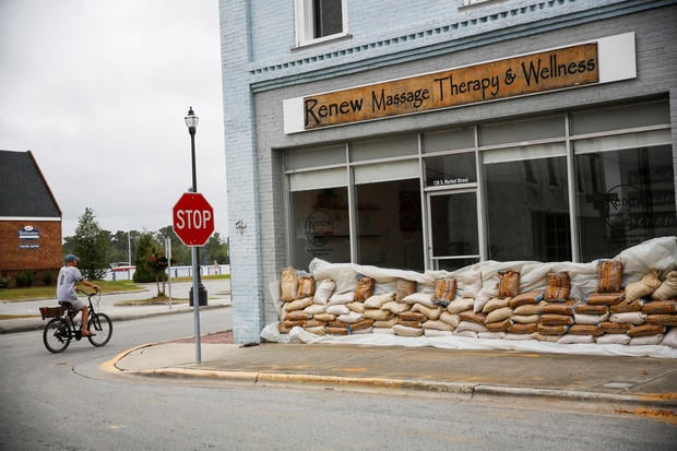 A man rides his bike around the waterfront docks before Hurricane Florence comes ashore in Washington