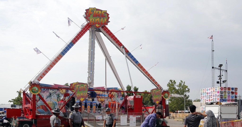 Passers by look at the fire ball ride as Ohio State Highway Patrol troopers stand guard at the Ohio State Fair Thursday