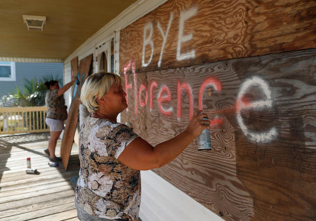 Lisa Evers and her daughter Amanda Hamilton, both of Oak Island, decorate their storm shutters before evacuating ahead of the arrival of Hurricane Florence in Oak Island 