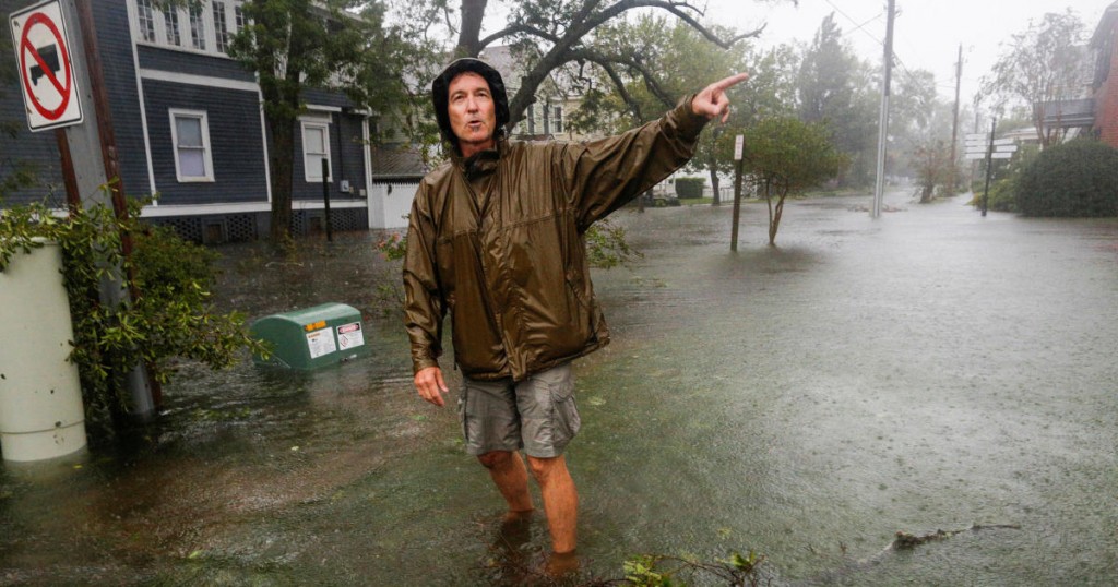 A man walks through flooded streets during the passing of Hurricane Florence in the town of New Bern