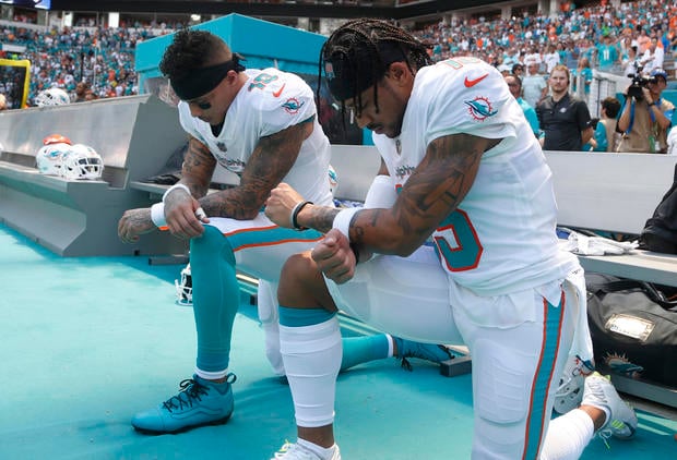 Miami Dolphins wide receiver Kenny Stills (10) and Miami Dolphins wide receiver Albert Wilson (15) kneel during the national anthem before an NFL football game against the Tennessee Titans