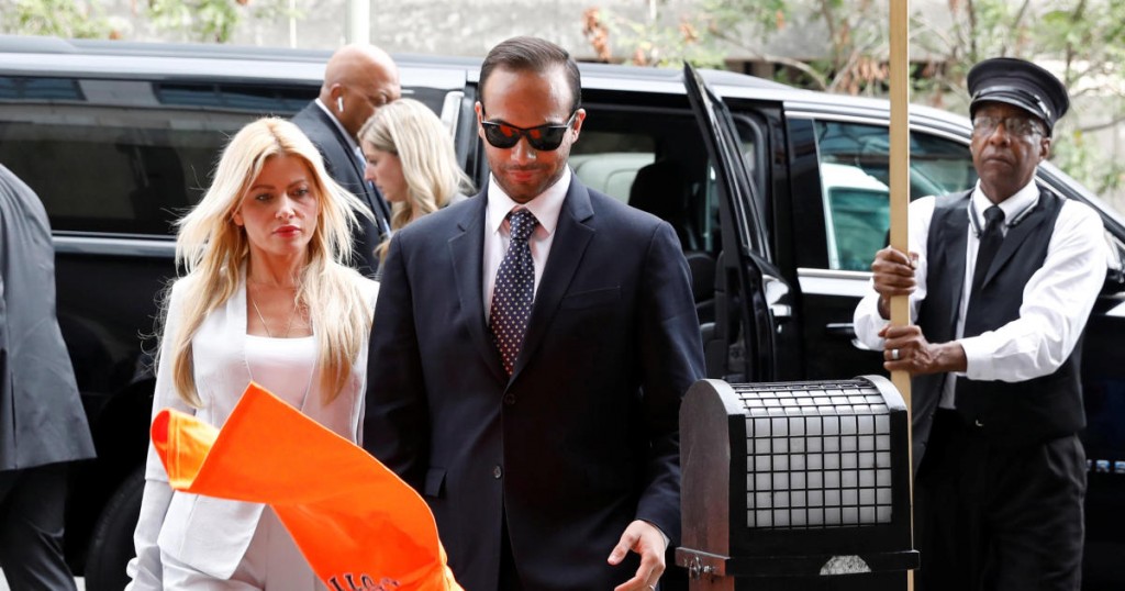 A protester throws an orange t-shirt as former Trump campaign aide George Papadopoulos with his wife Simona Mangiante arrives for his sentencing hearing at U.S. District Court in Washington