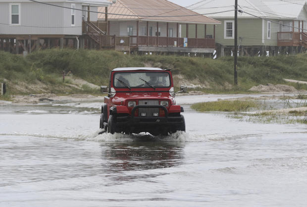 A vehicle drives through a flooded street from Tropical Storm Gordon on Wednesday
