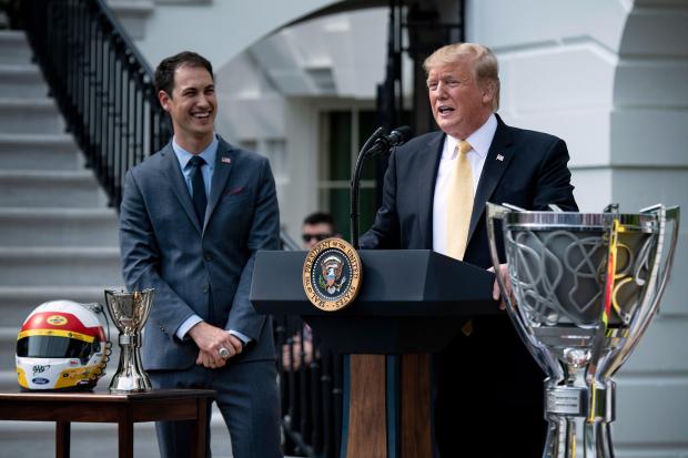 2018 NASCAR Cup Series Champion Joey Logano listens while US President Donald Trump speaks during an event on the South Lawn of the White House  April 30