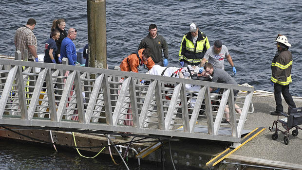 Emergency response crews transport an injured passenger to an ambulance at the George Inlet Lodge docks
