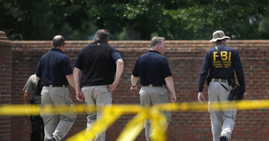 Law enforcement officials walk down a ramp to enter a municipal building that was the scene of a shooting