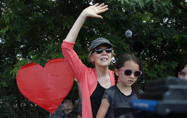 Senator of Massachusetts and Democratic presidential hopeful Elizabeth Warren stands on a ladder with an unidentified girl