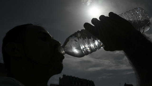 A person drinks water from a plastic bottle in Mulhouse