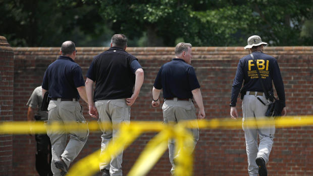Law enforcement officials walk down a ramp to enter a municipal building that was the scene of a shooting