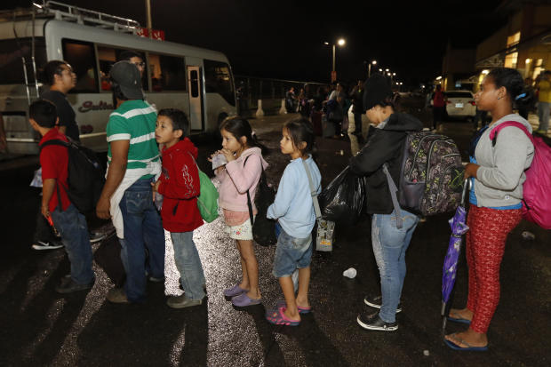 Migrants hoping to reach the U.S. wait in line to board a bus toward Honduras' border with Guatemala as hundreds of migrants set off by bus or on foot from a main bus station in San Pedro Sula