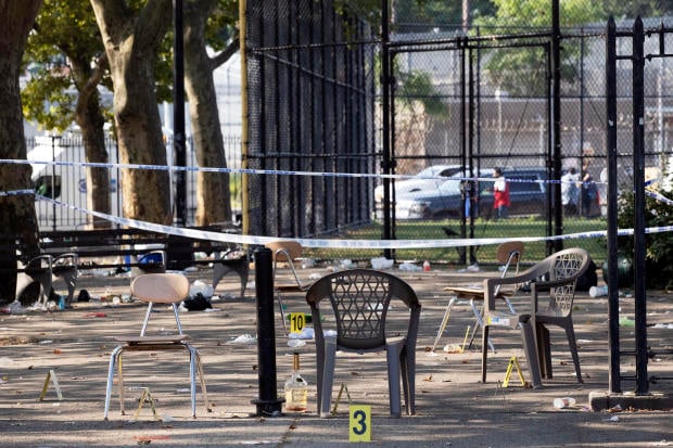 Yellow evidence markers are placed next to chairs at a playground in the Brownsville neighborhood in the Brooklyn borough of New York