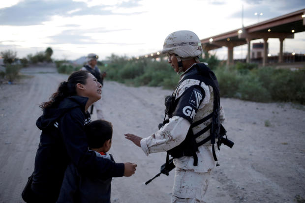 Guatemalan migrant Ledy Perez embraces her son Anthony while asking a member of the Mexican National Guard to let them cross into the United States from Ciudad Juarez, Mexico, July 22, 2019.