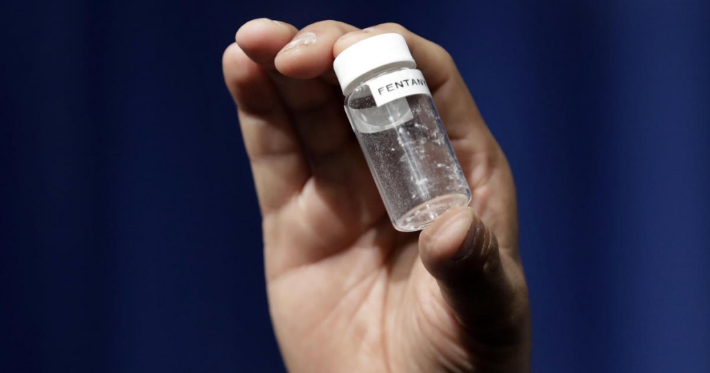 A reporter holds up an example of the amount of fentanyl that can be deadly after a news conference about deaths from fentanyl exposure
