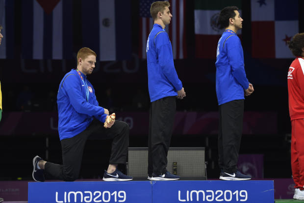 TOPSHOT - US' Race Imboden(L) kneels next to Nick Itkin(C)