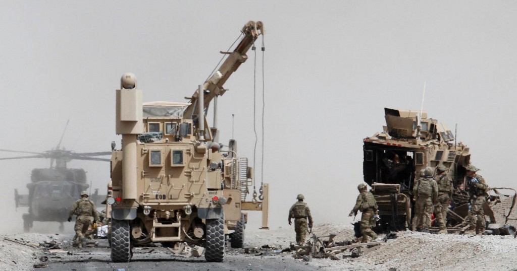 U.S. troops assess the damage to an armoured vehicle of NATO-led military coalition after a suicide attack in Kandahar province